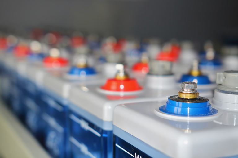 Rows of batteries with red and blue terminals. — Foto por Vanya Smythe na Unsplash