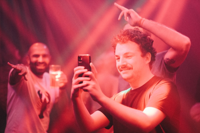 a man taking a picture with his cell phone — Foto por peter bucks na Unsplash